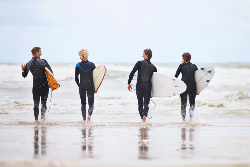 benefits of surfing-are-beyond-invigorating group of surfers on beach